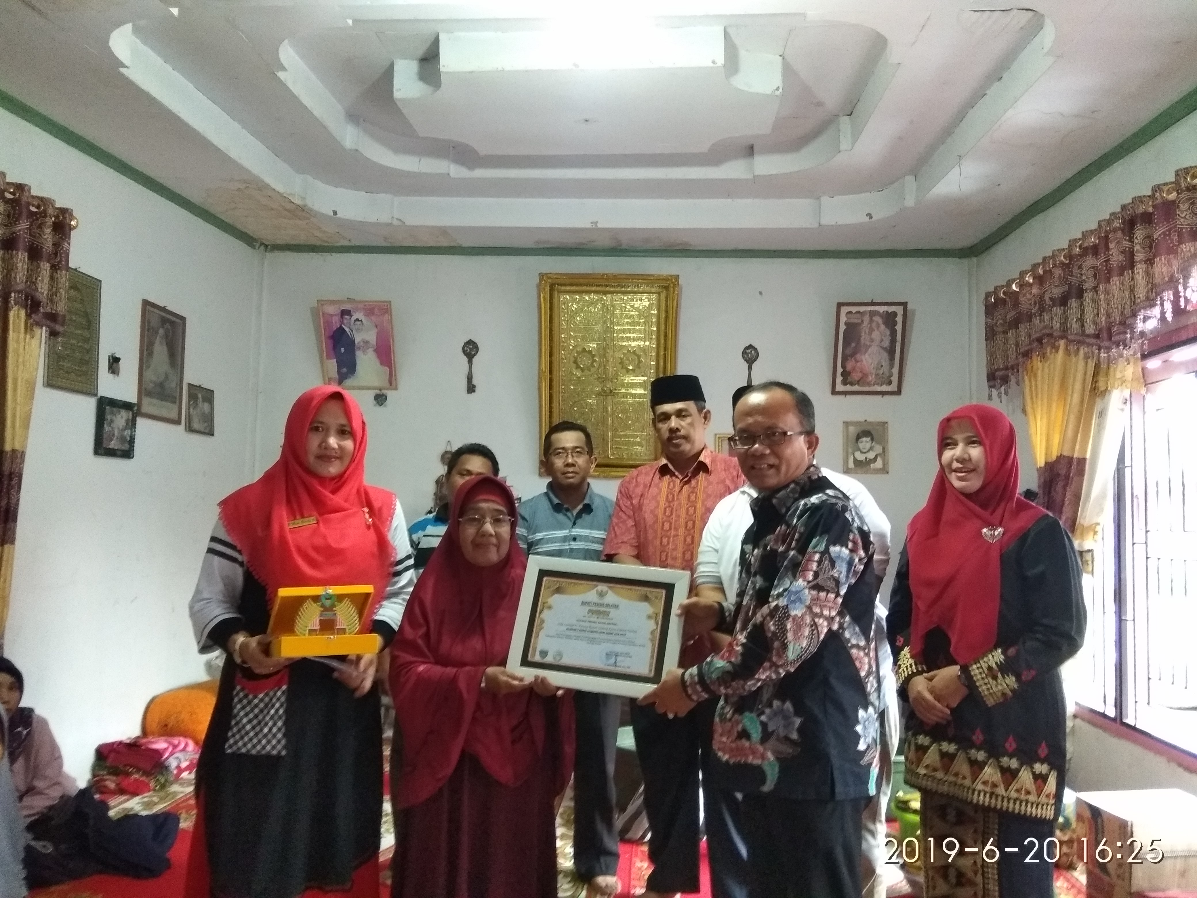 Sekda Serahkan Cenderamata Kepada Pemilik Rumah Gadang Tempat Khafilah Menginap 